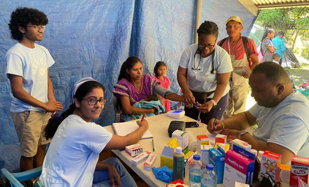 Dr. Suja Mathai, her son Ethan, Nurse Practitioner Marie Castor and Pastor Rey Edward providing care under a makeshift outdoor tent on their medical mission trip to Panama | ID Care | New Jersey