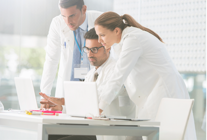 Three doctors looking at a computer screen discussing infectious disease studies | ID Care | NJ