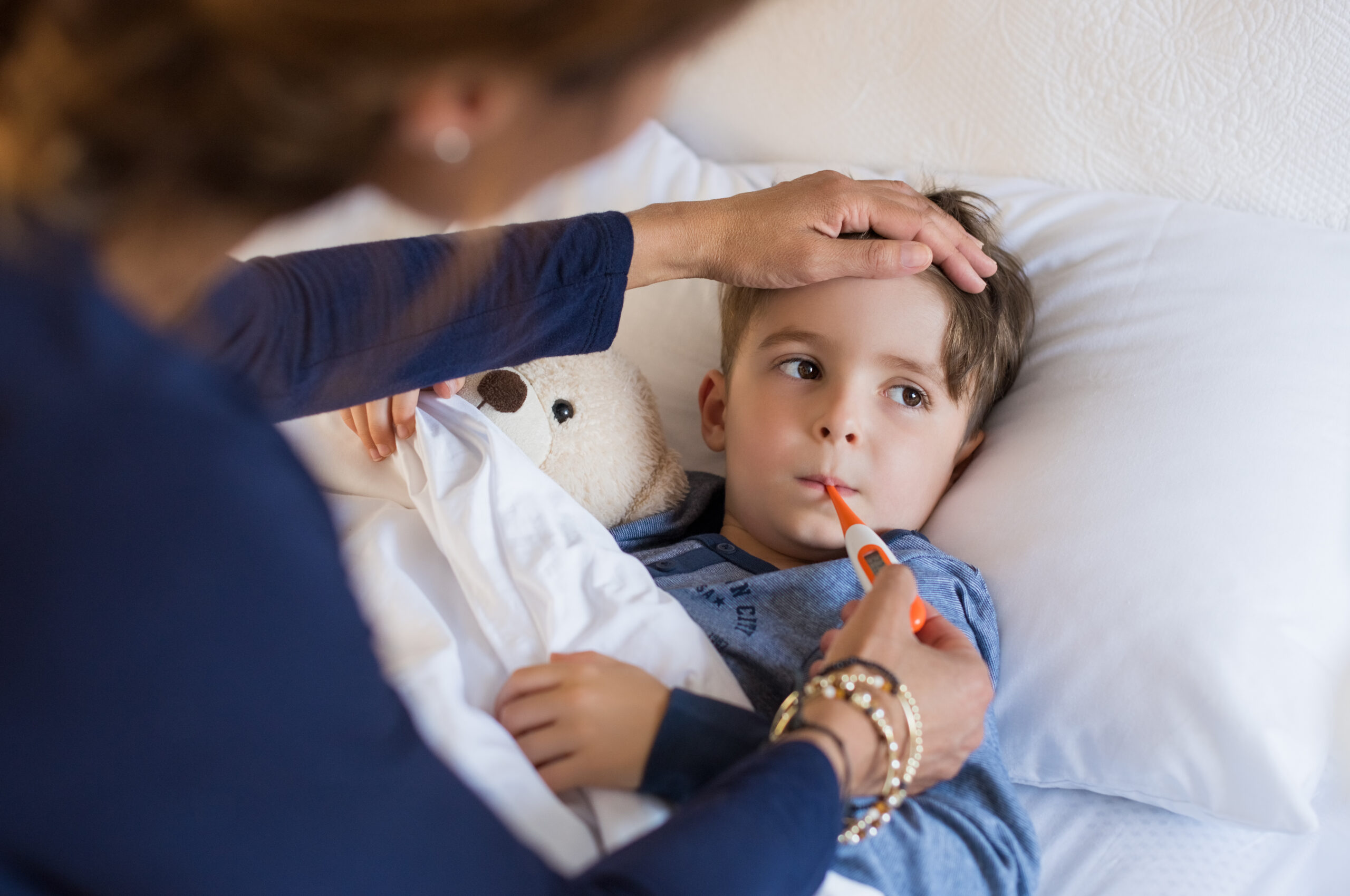 Boy in bed getting his temperature taken | Blog about MMR vaccine myths | ID Care | Hillsborough, NJ